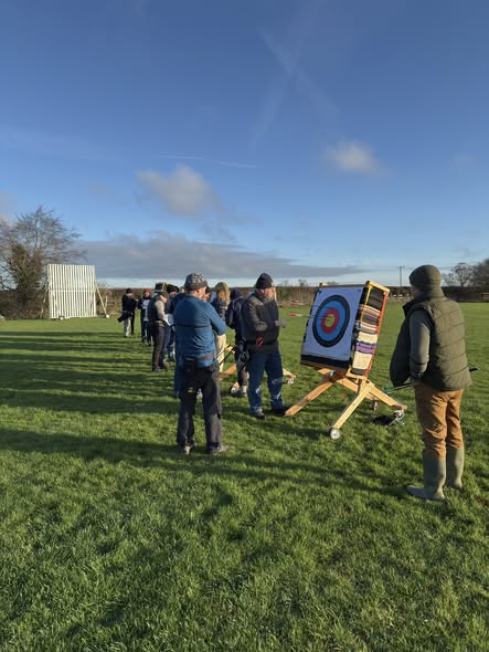 Archers looking at targets under a blue sky